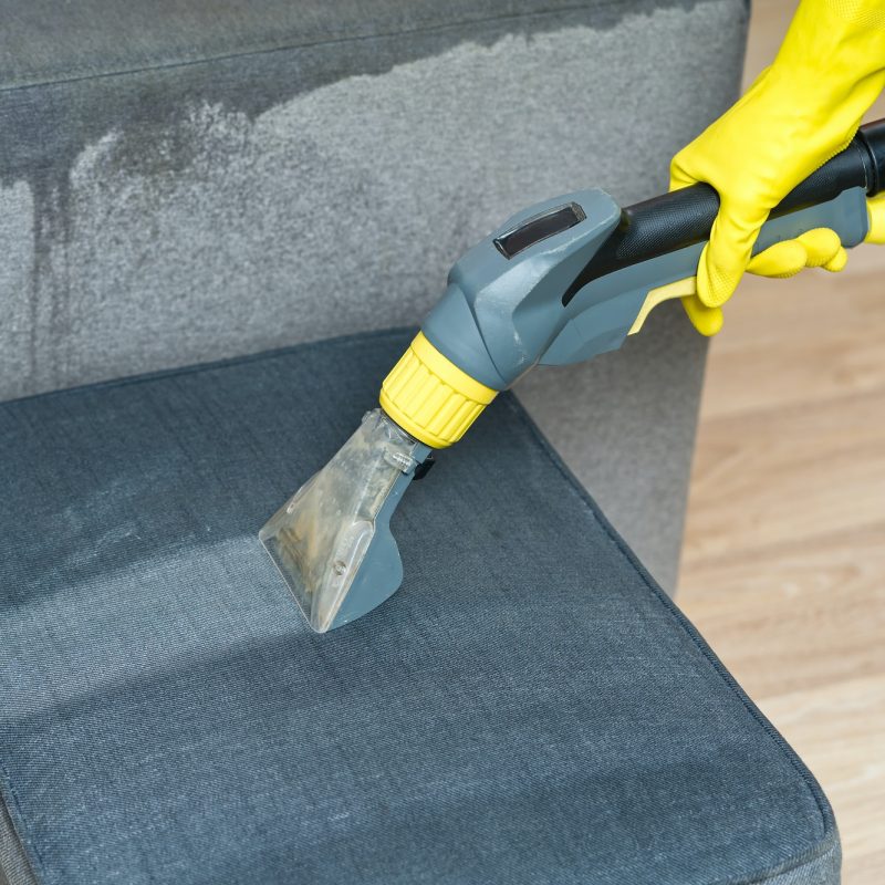 Sofa chemical cleaning with professionally extraction method. Wet textile sofa cleaning